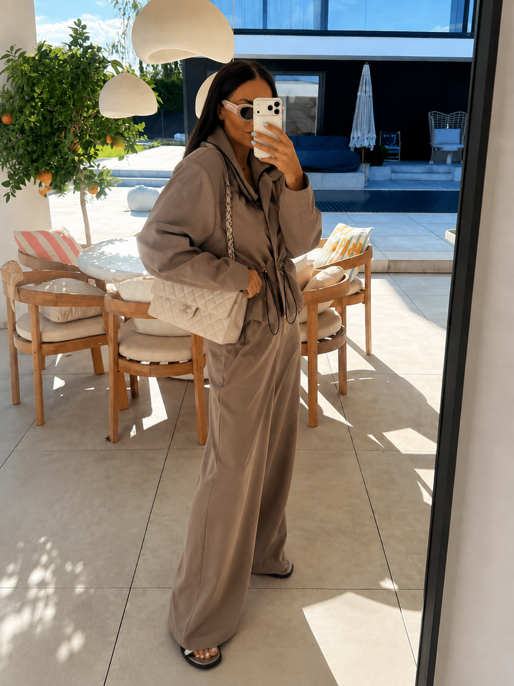 Ciemny beż komplet kurtka na zamek i szerokie spodnie, ujęcie z boku