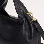 Czarny torebka skórzana worek do ręki z paskiem crossbody, detal materiału