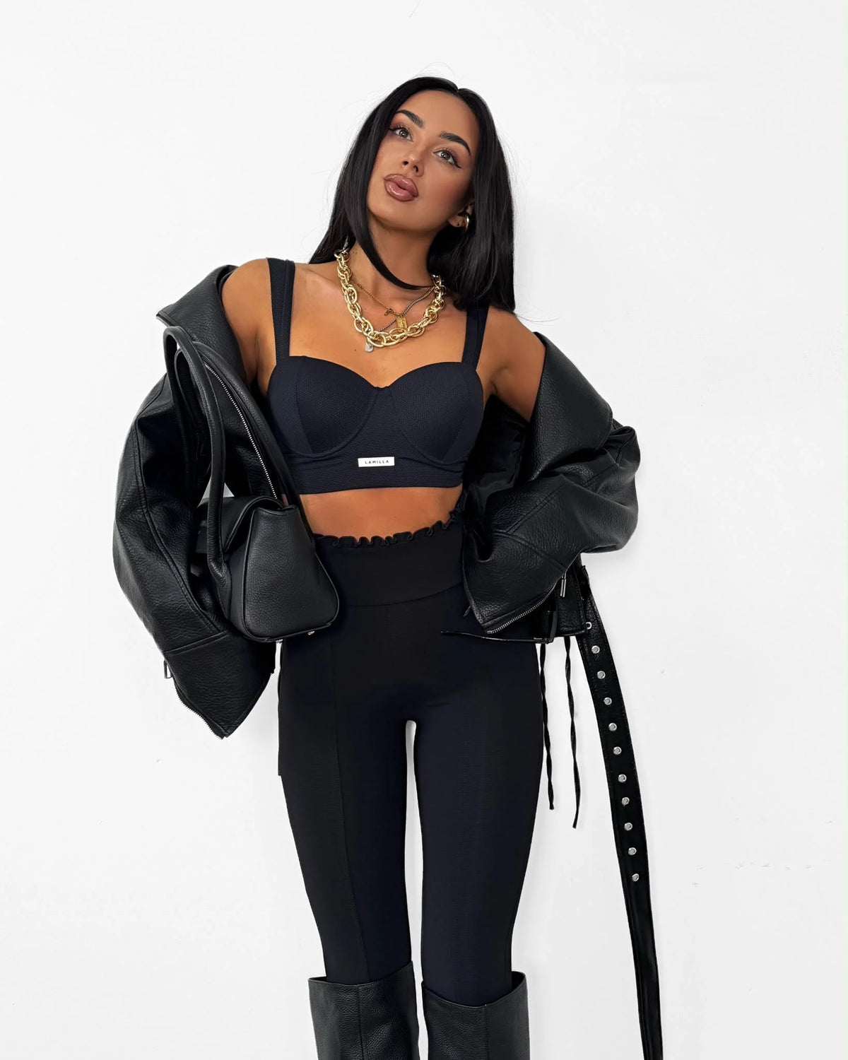 Czarny — legginsy z falbanką przy pasie, przód na modelce z czarną kurtką