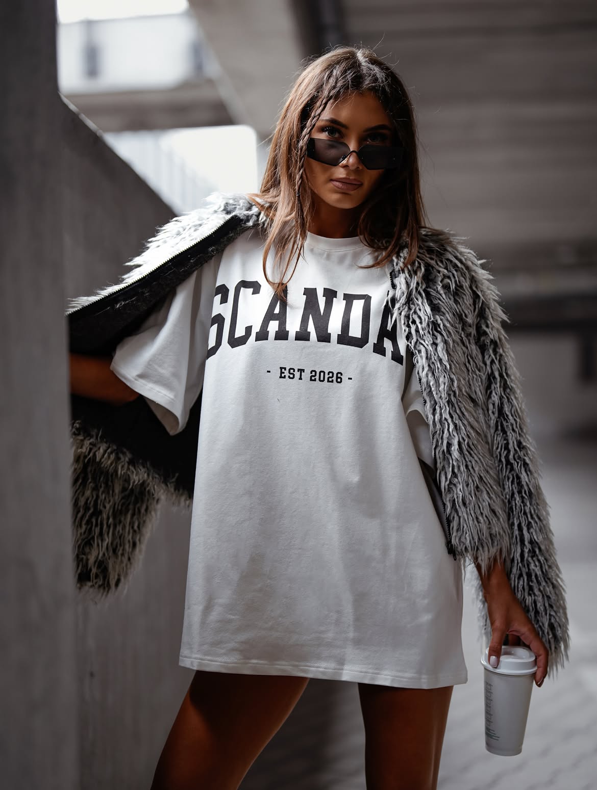 Biały z czarnym napisem — t-shirt oversize z nadrukiem Scandal, stylizacja z futrzaną kurtką