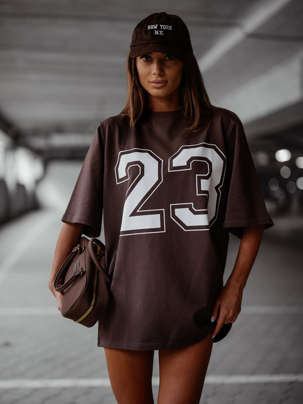 Czekoladowy — t-shirt oversize z numerem 23, cała sylwetka z torebką