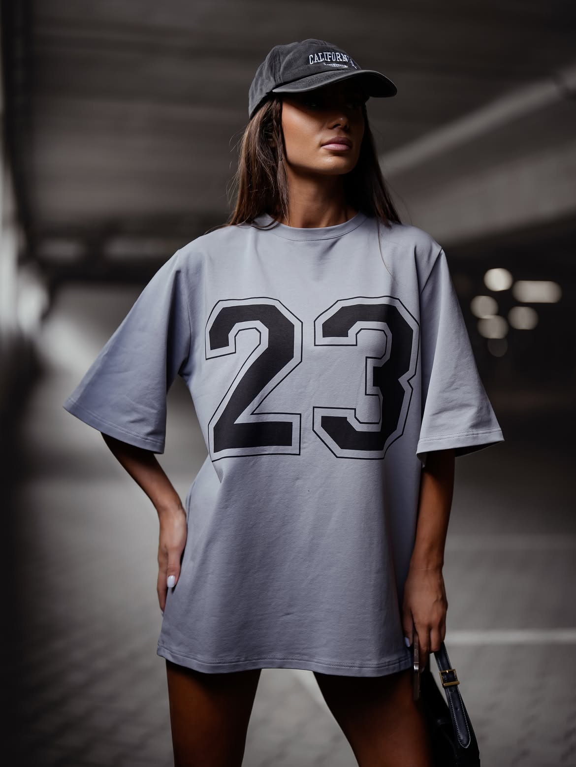 Szary — t-shirt oversize z numerem 23, przód, ręka w kieszeni